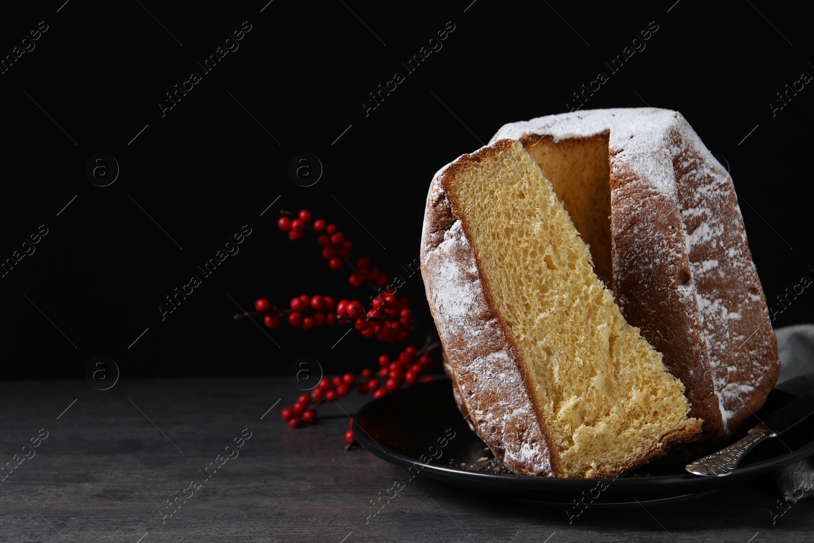 Photo of Delicious Pandoro cake with powdered sugar and decor on grey table, space for text. Traditional Italian pastry