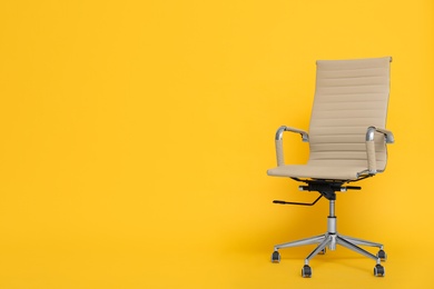 Modern office chair on yellow background. Space for text