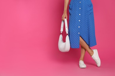 Photo of Woman with stylish bag on pink background, closeup. Space for text