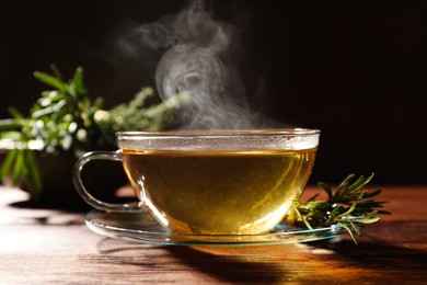 Photo of Cuparomatic herbal tea and fresh rosemary on wooden table