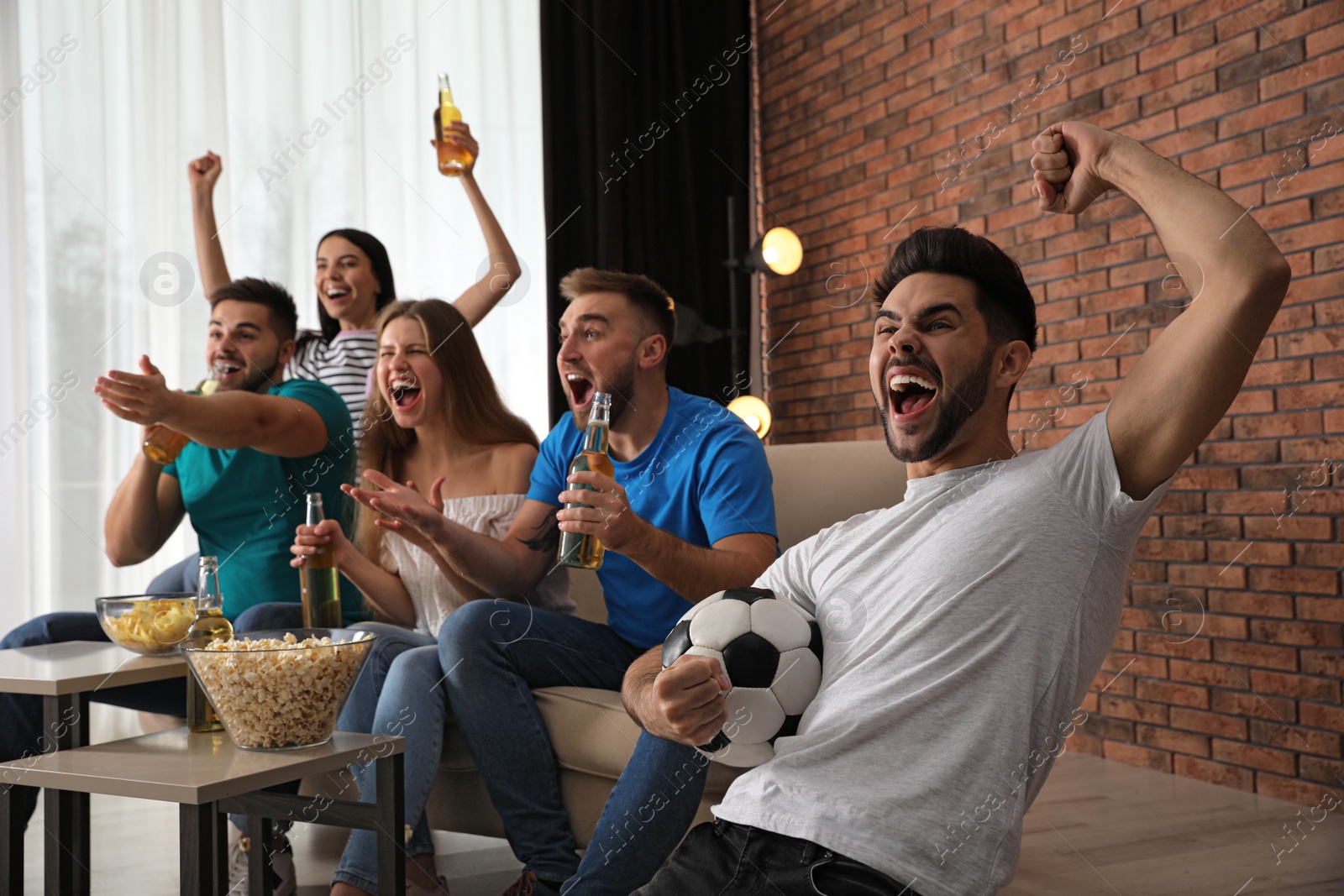 Photo of Group of friends watching football at home