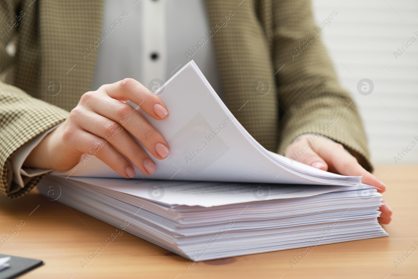 Photo of Woman working with documents at table in office, closeup