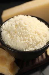 Photo of Bowl with grated parmesan cheese on table, closeup