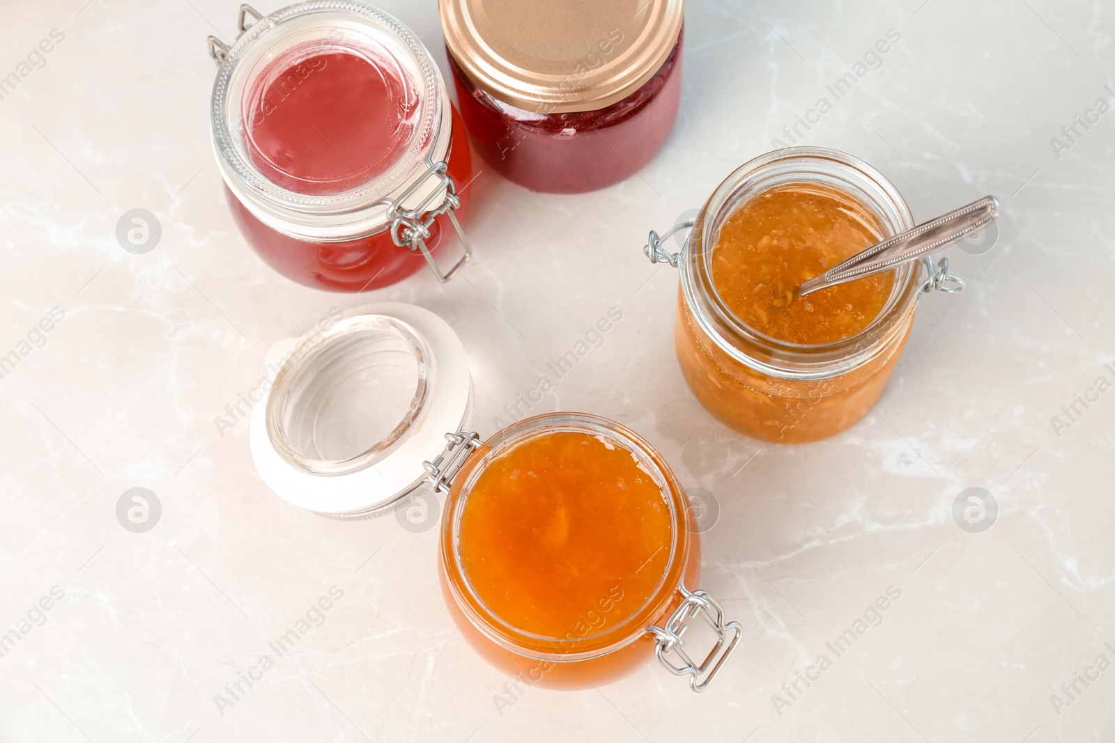 Photo of Jars with different sweet jam on table