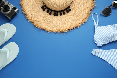 Photo of Flat lay composition with straw hat on blue background. Space for text