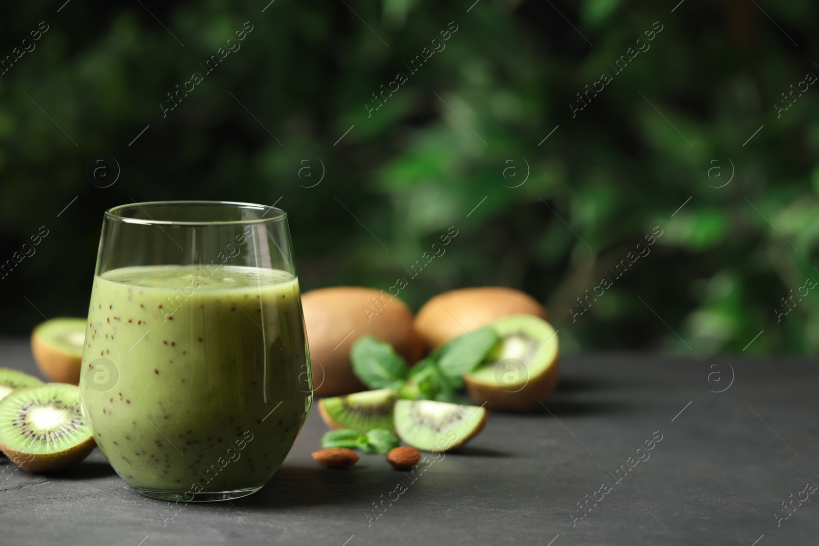 Photo of Delicious kiwi smoothie and fresh fruits on grey table. Space for text