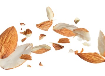 Image of Pieces of tasty almonds falling on white background