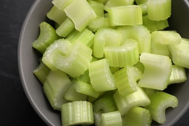 One bowl of fresh cut celery on grey table, top view