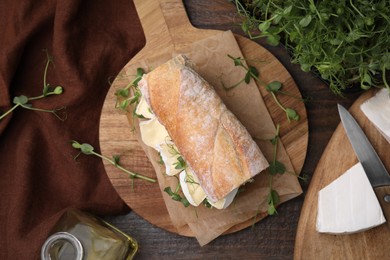 Photo of Tasty brie cheese sandwich on wooden table, flat lay