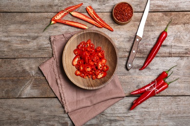 Flat lay composition with chili peppers on wooden background