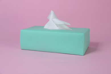 Photo of Box with paper tissues on pink background