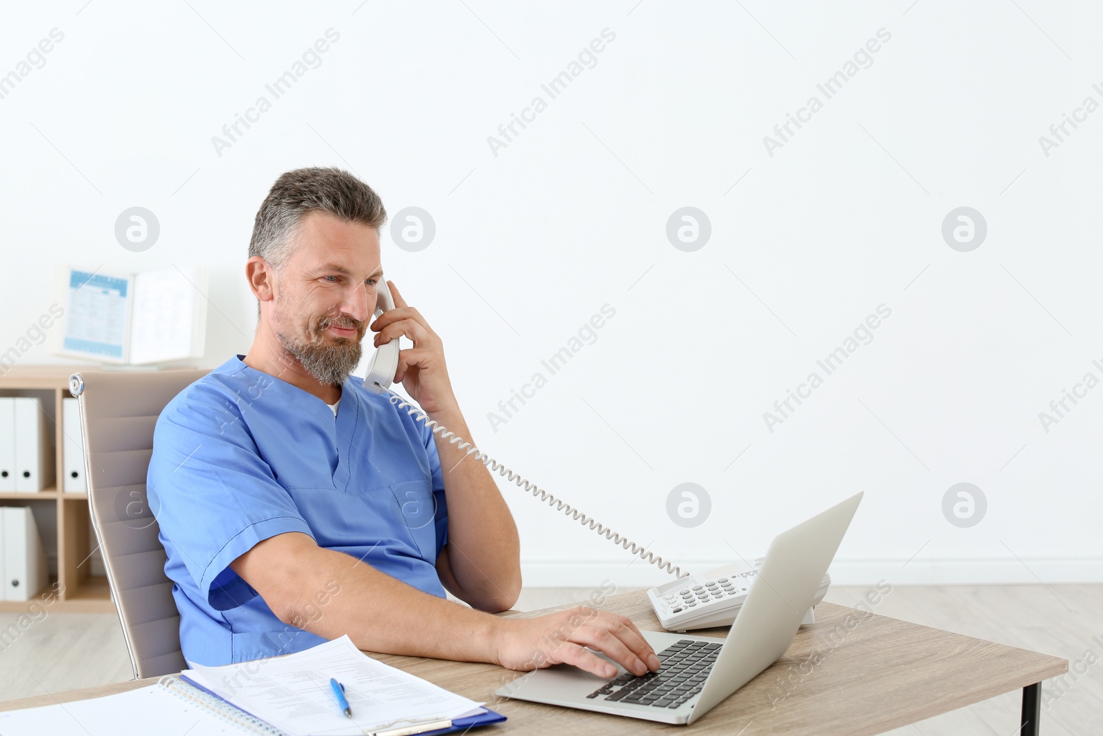 Photo of Male medical assistant at workplace in clinic. Health care service