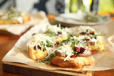 Photo of Delicious bruschettas with beef and cheese on table