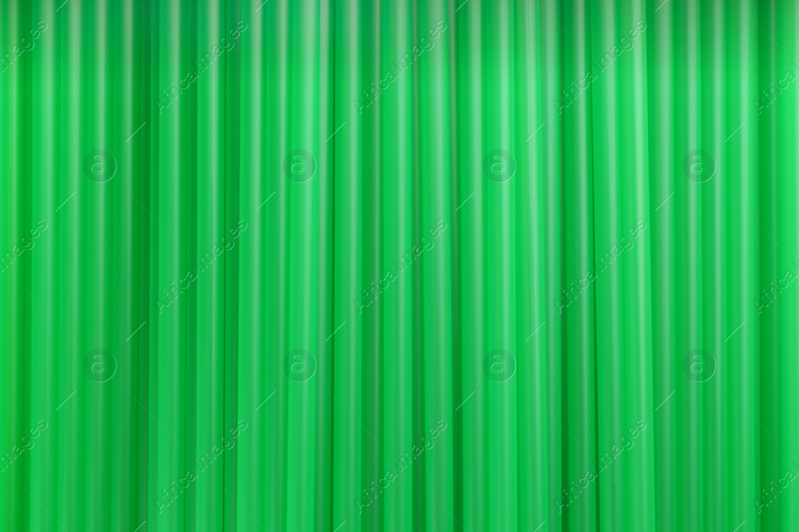 Photo of Heap of green plastic straws for drinks as background, closeup