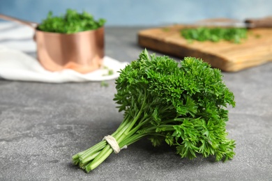 Photo of Fresh green parsley on grey table, space for text