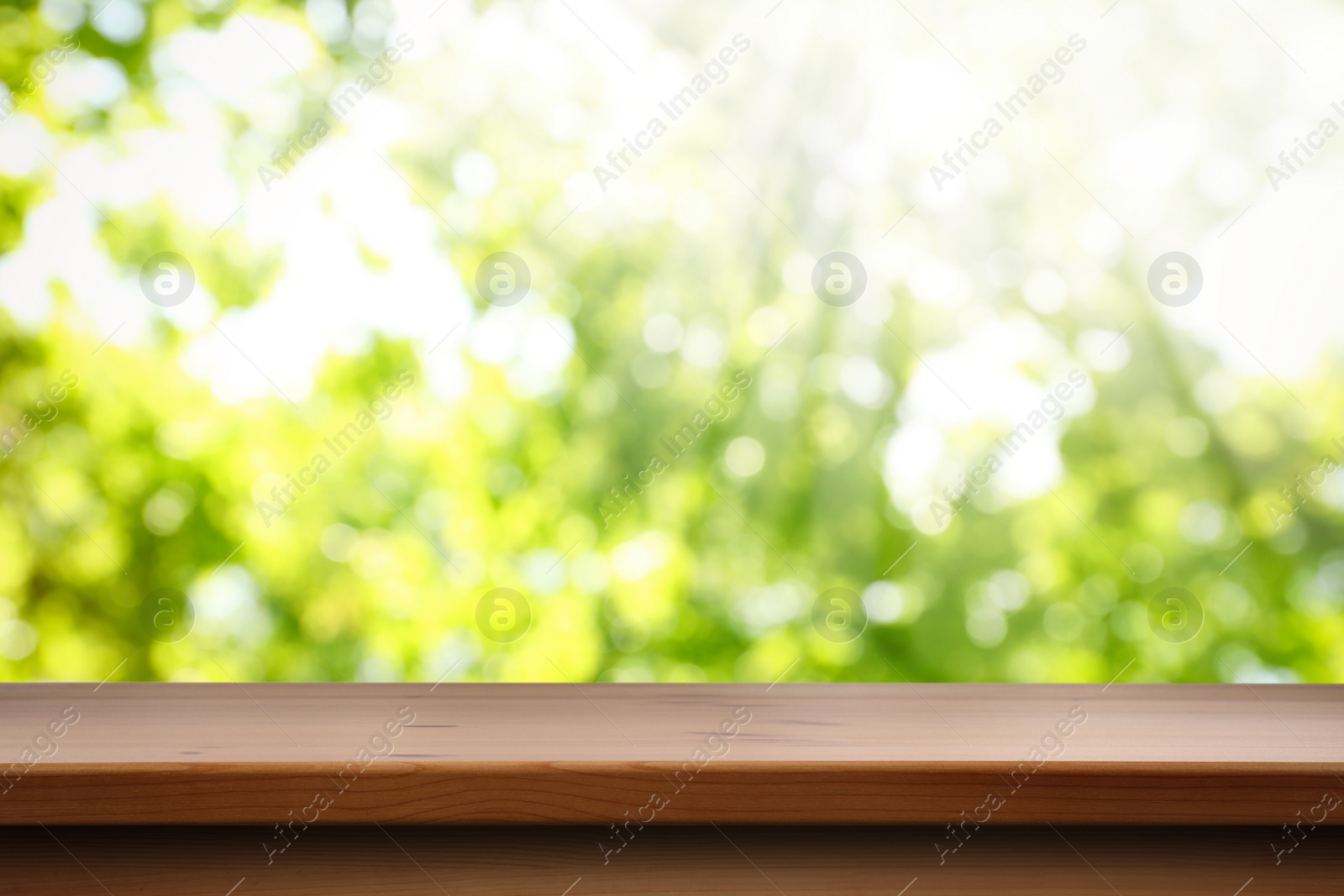 Image of Empty wooden surface against blurred green background. Space for design