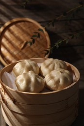 Photo of Delicious bao buns (baozi) in bamboo steamer, closeup