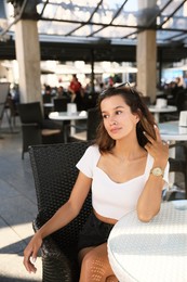 Portrait of beautiful young woman in outdoor cafe