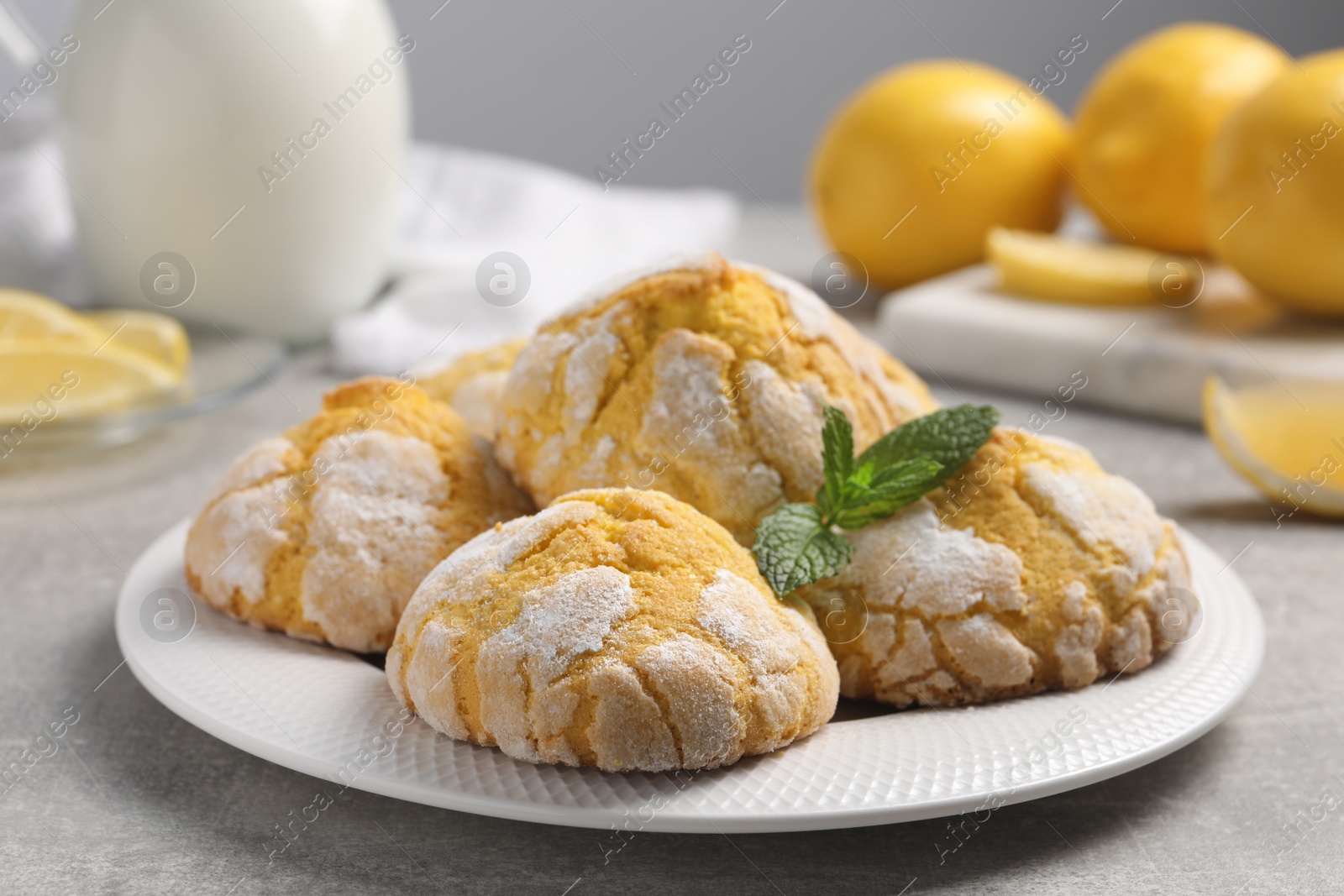 Photo of Plate with delicious lemon cookies and mint on grey table, closeup