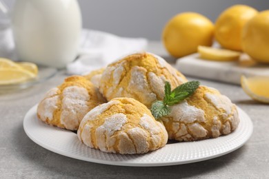 Photo of Plate with delicious lemon cookies and mint on grey table, closeup