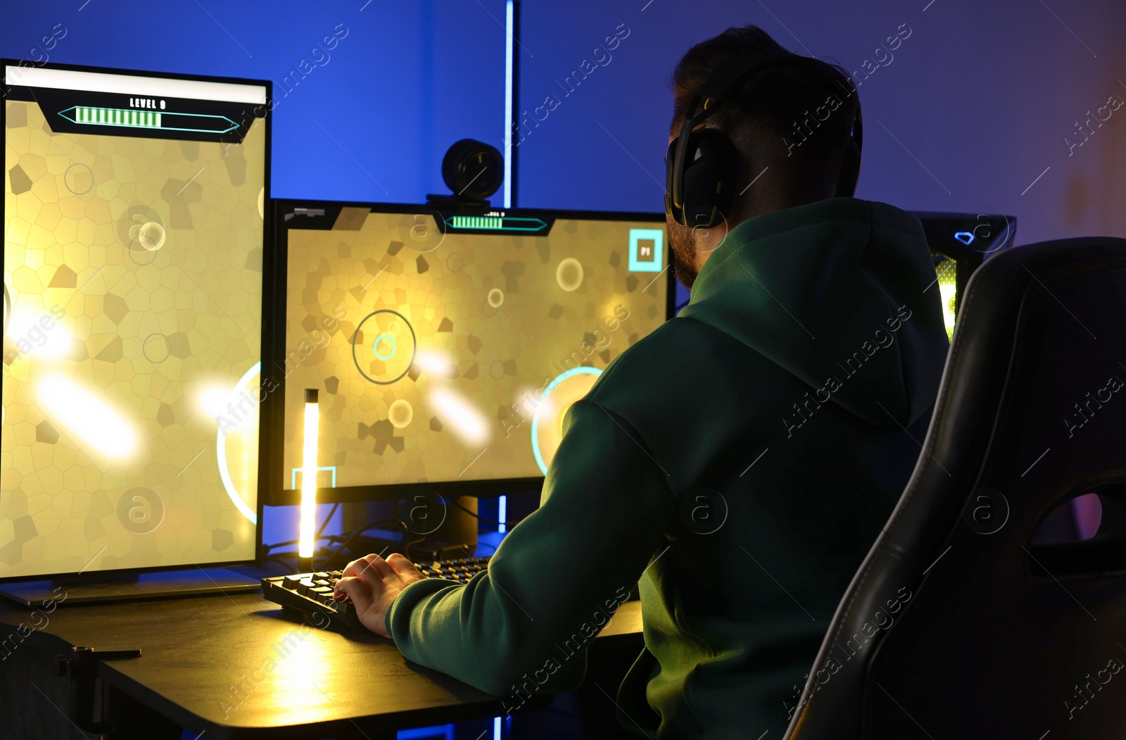 Photo of Man playing video games on computer at table indoors