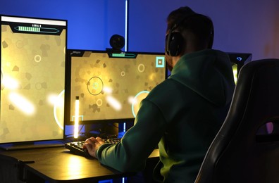 Man playing video games on computer at table indoors