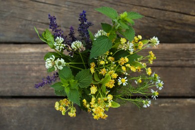 Photo of Bouquet of different fresh herbs on wooden table, top view