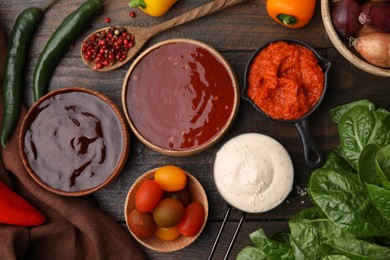 Photo of Different marinades and products on wooden table, flat lay