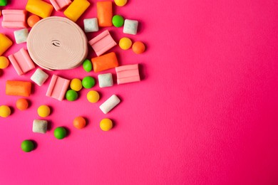 Photo of Many different chewing gums on pink background, flat lay. Space for text