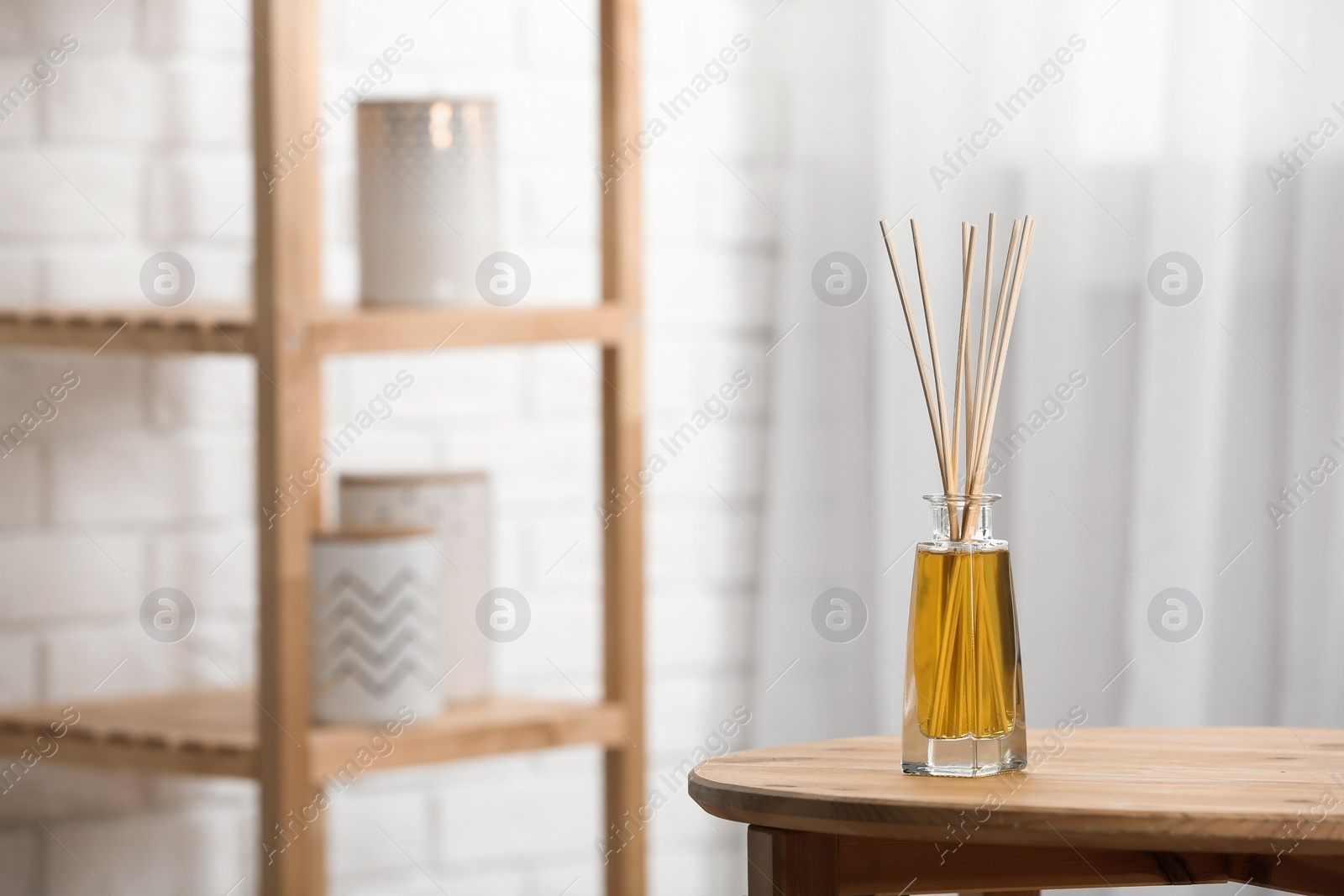 Photo of Reed air freshener on wooden table indoors, space for text