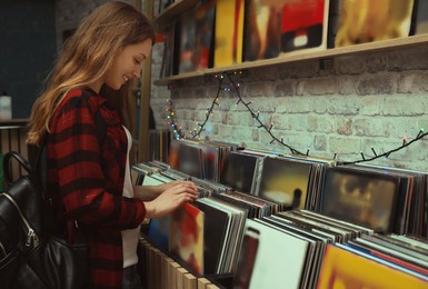 Young woman choosing vinyl records in store