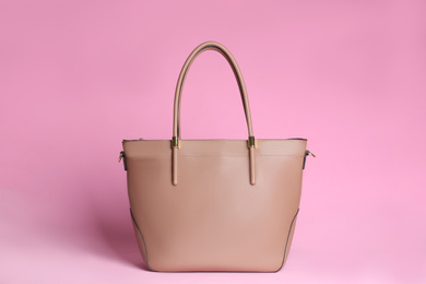 Photo of Stylish woman's bag on light pink background