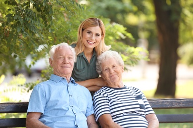 Woman with elderly parents in park on sunny day