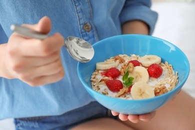 Photo of Woman eating delicious oatmeal with fruits, closeup. Healthy diet