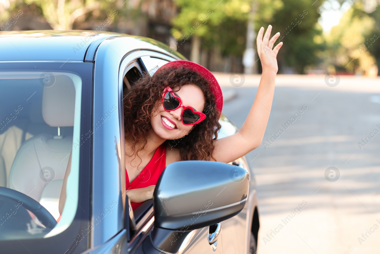 Photo of Young beautiful African-American woman wearing heart shaped glasses in car