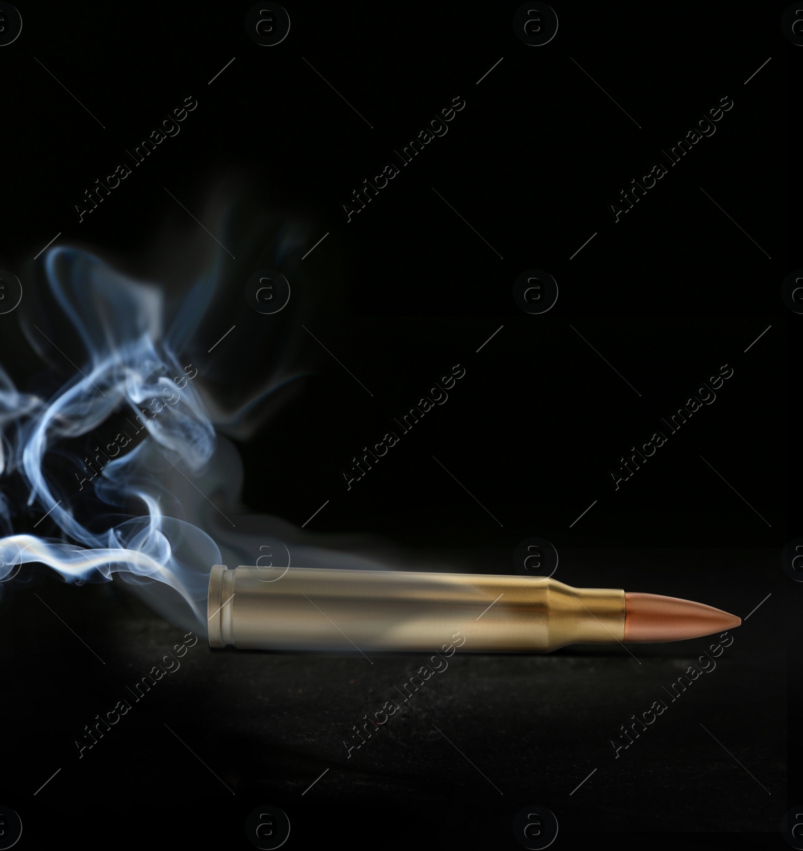 Image of One bullet with smoke on black background