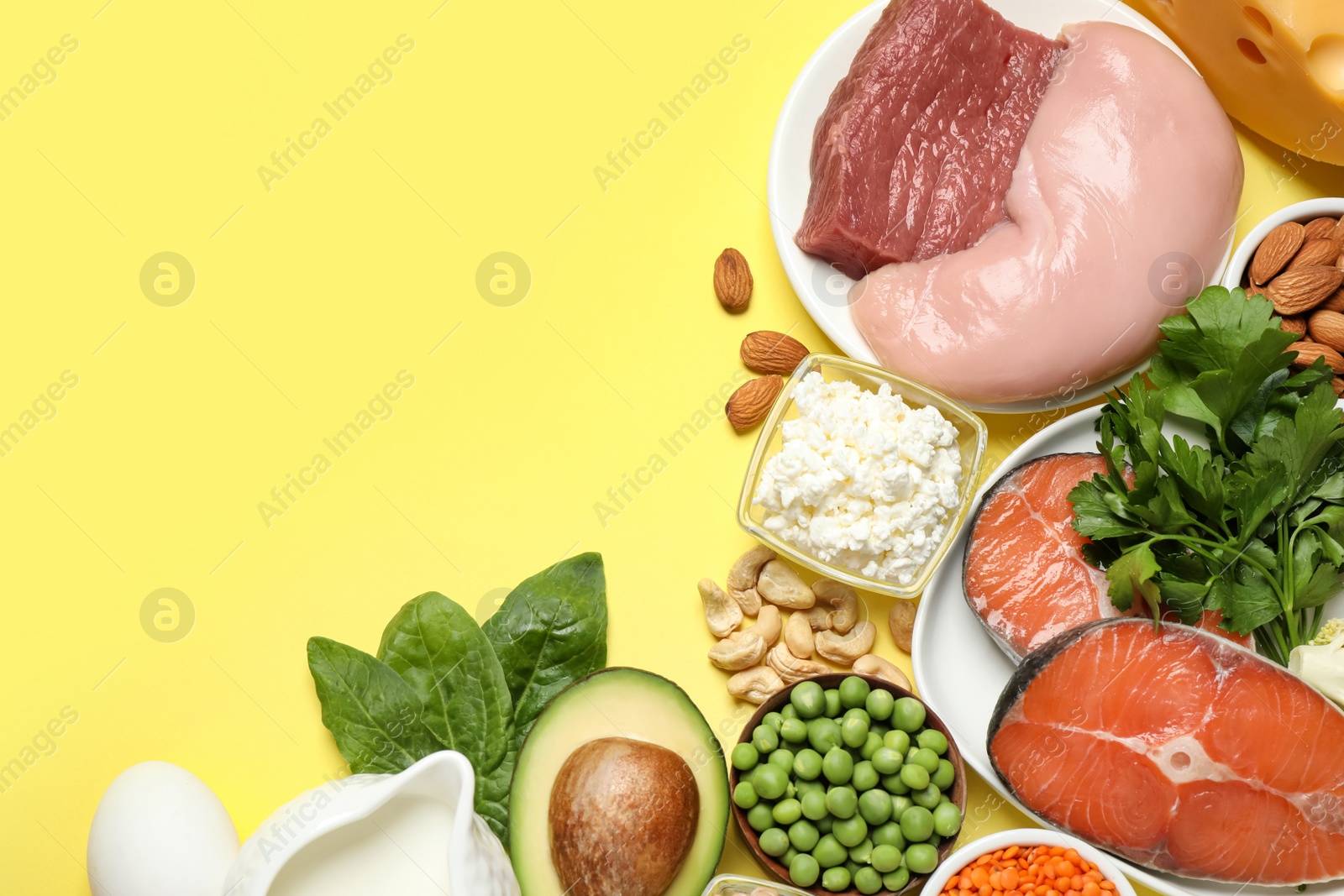 Photo of Different products rich in protein on yellow background, flat lay. Space for text