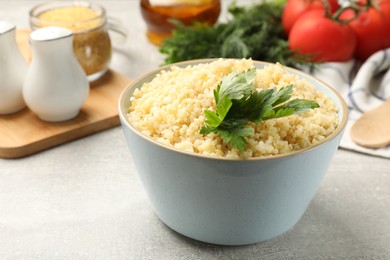 Photo of Delicious bulgur with parsley on light grey table, closeup