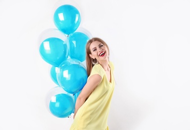 Young woman with air balloons on white background