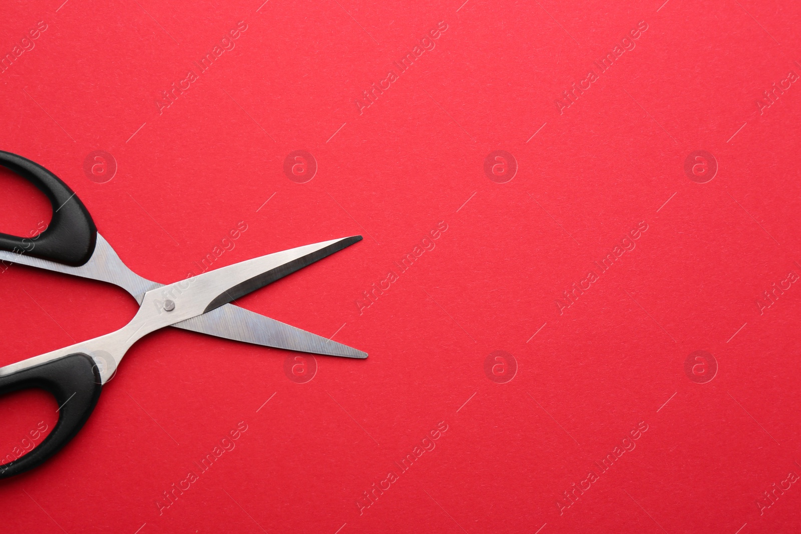 Photo of Pair of sharp scissors on color background, top view. Space for text