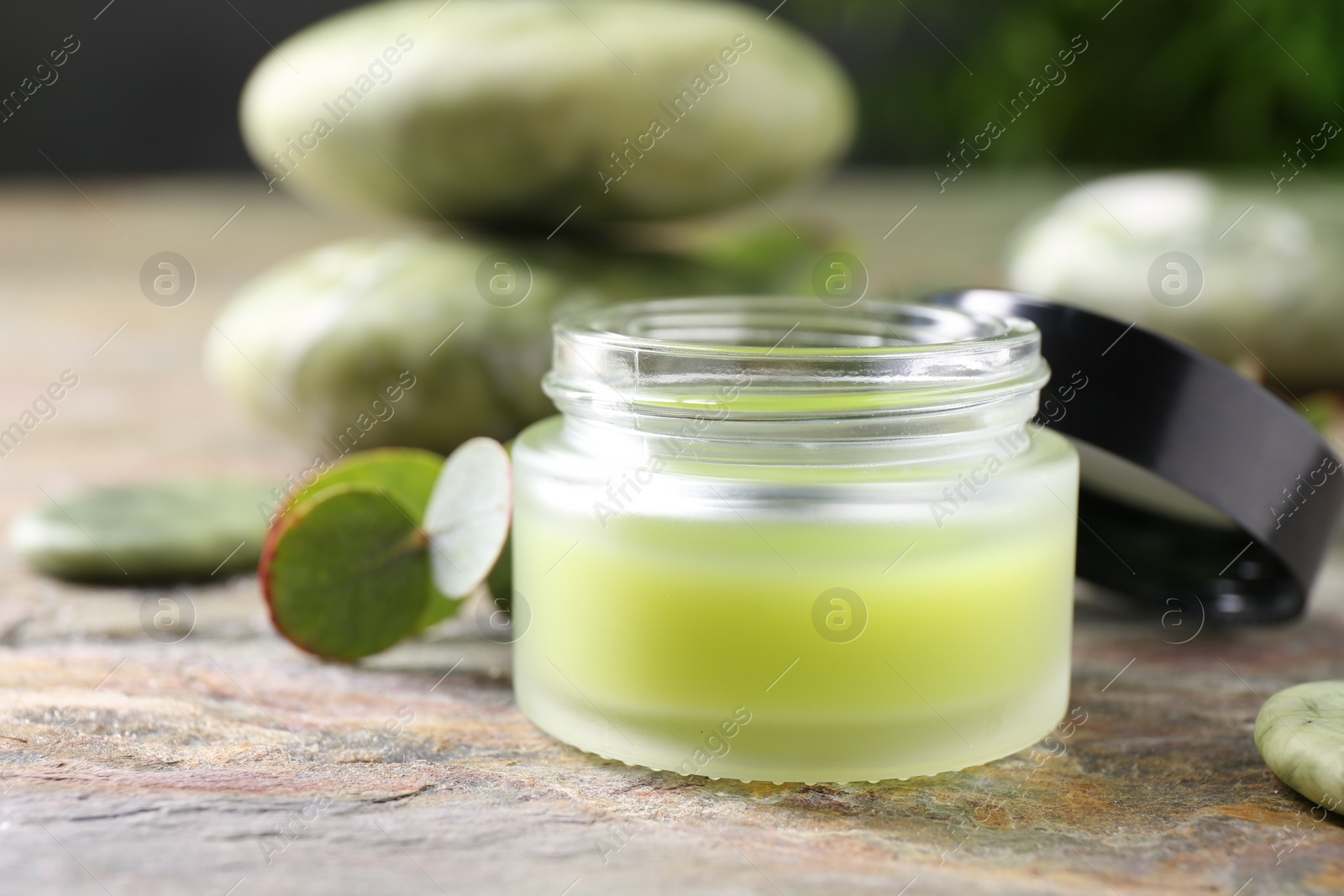 Photo of Jar of cream on textured table, closeup. Body care product