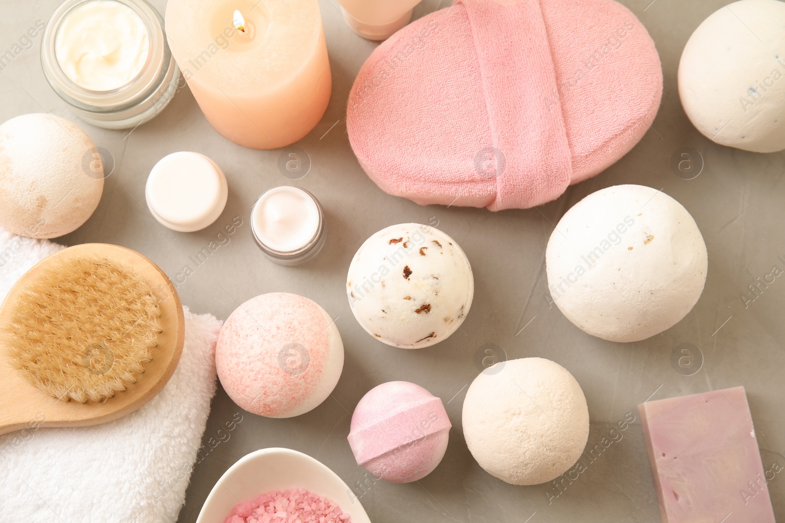 Photo of Flat lay composition with bath bombs and toiletries on grey background