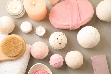 Photo of Flat lay composition with bath bombs and toiletries on grey background