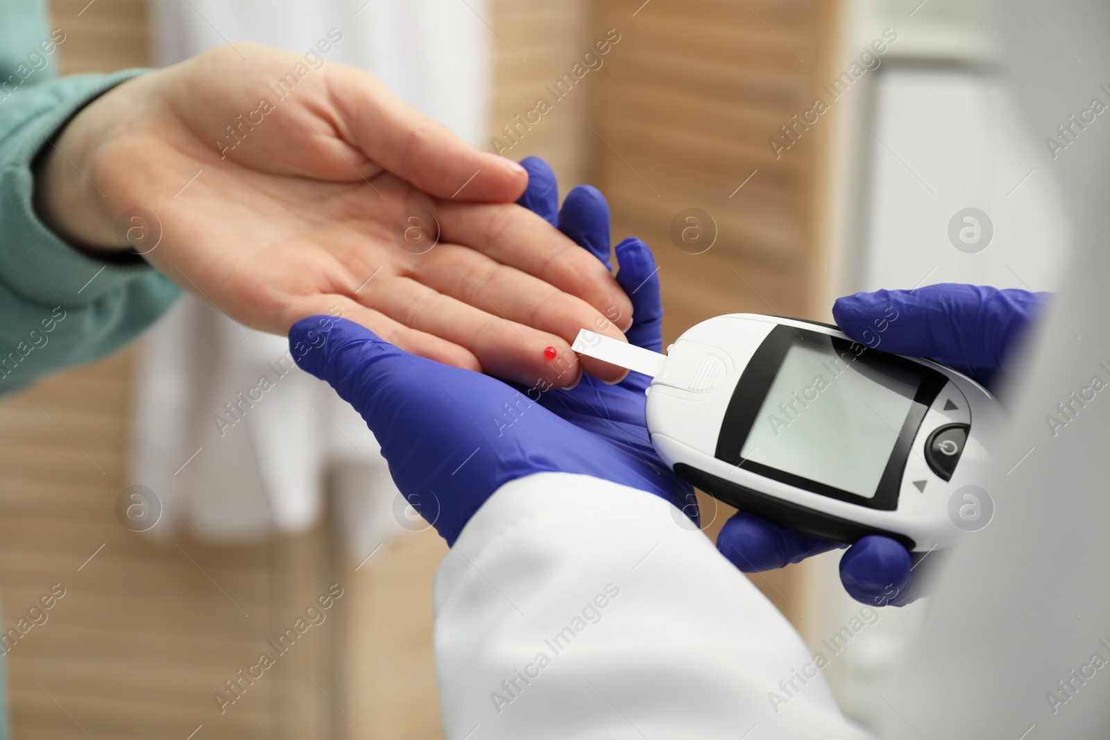 Photo of Diabetes. Doctor checking patient's blood sugar level with glucometer in clinic, closeup