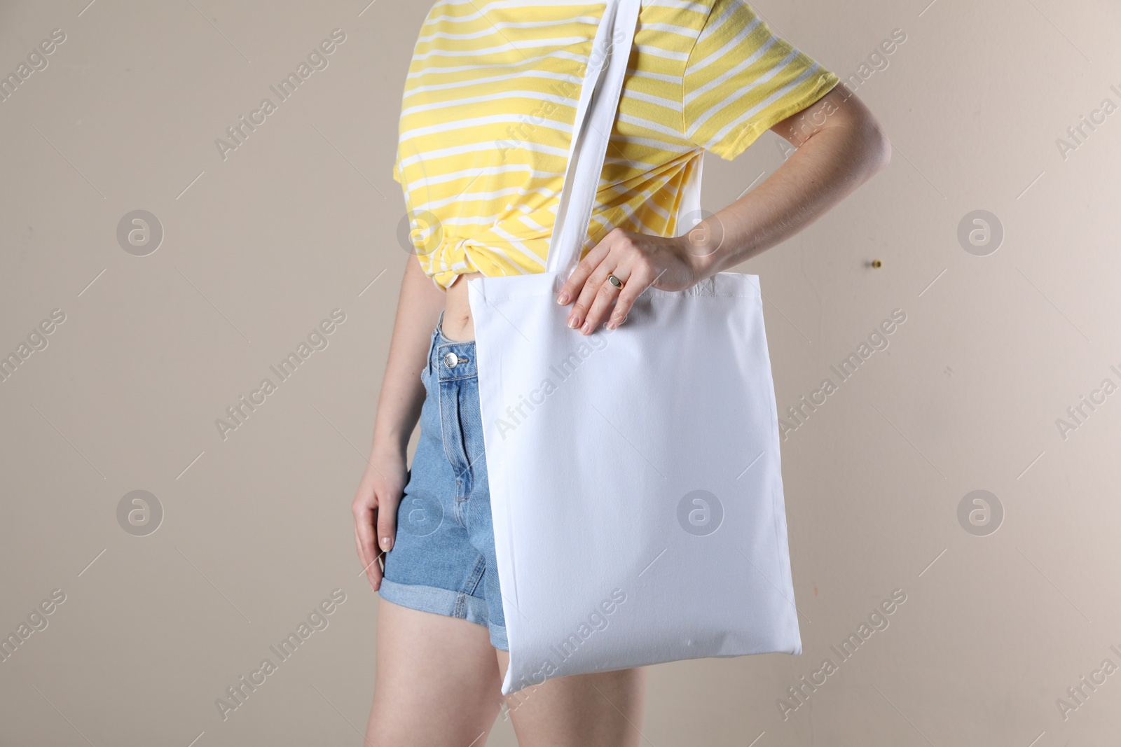 Photo of Woman with textile bag on beige background, closeup. Space for design