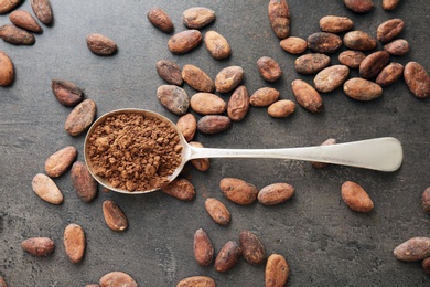 Flat lay composition with cocoa powder and beans on grey background