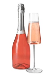 Photo of Bottle and glass of rose champagne isolated on white. Mockup for design