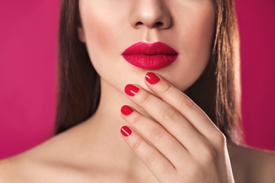 Photo of Beautiful woman with stylish nail polish on color background, closeup
