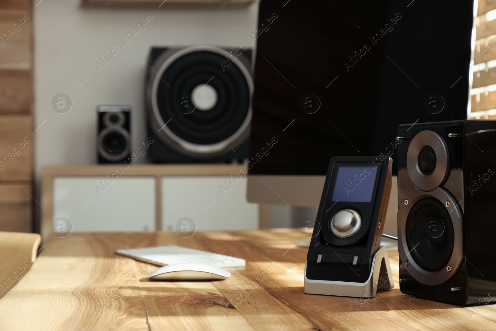 Photo of Modern computer with audio speaker system in bright room