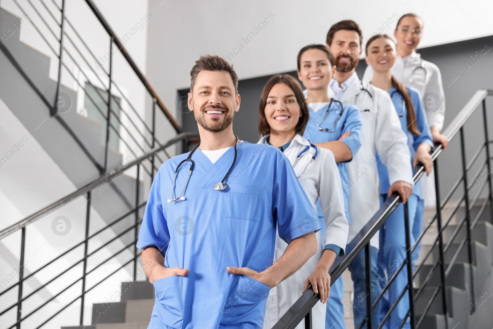 Photo of Team of professional doctors on staircase in clinic